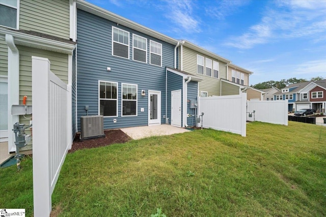 rear view of property featuring a yard and central AC