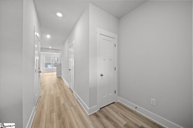 corridor with light hardwood / wood-style floors