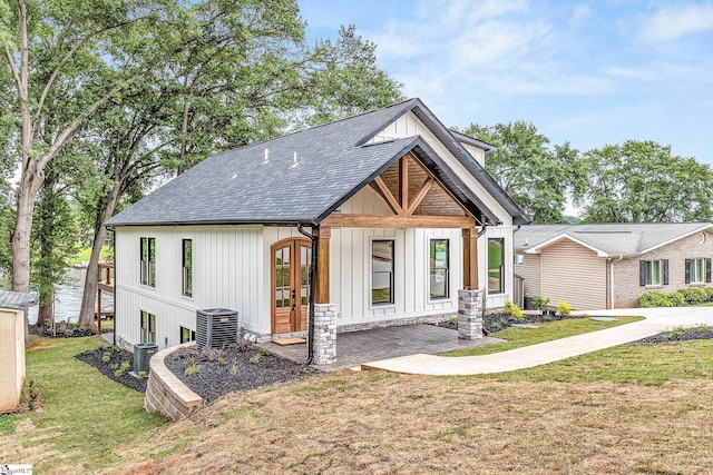 modern farmhouse with central AC unit and a front yard