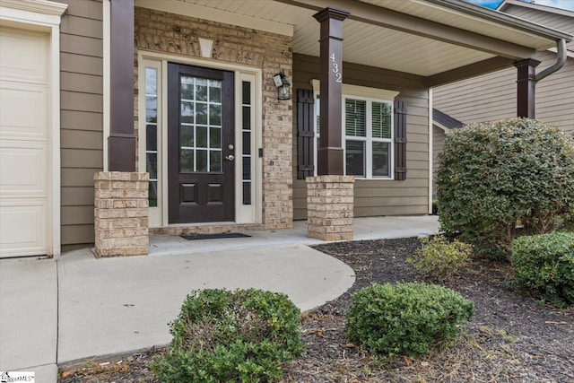 entrance to property featuring covered porch and a garage