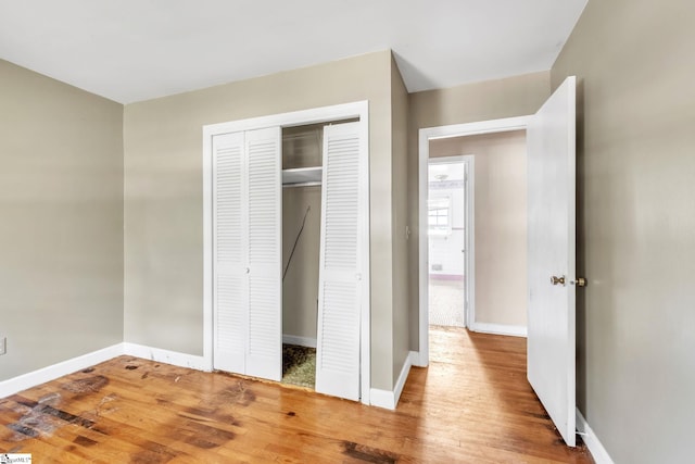 unfurnished bedroom with a closet and hardwood / wood-style flooring