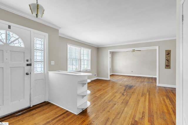 entrance foyer featuring light hardwood / wood-style floors, ornamental molding, and ceiling fan