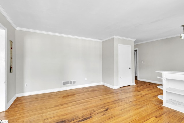 unfurnished room featuring ornamental molding and light wood-type flooring