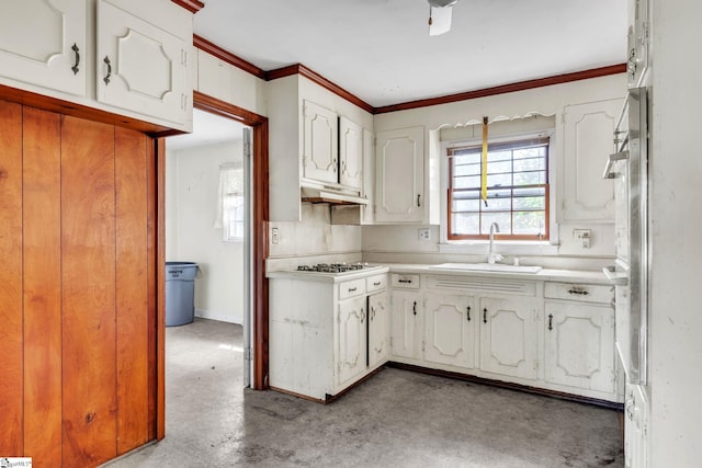 kitchen featuring crown molding, stainless steel gas stovetop, sink, concrete floors, and white cabinets