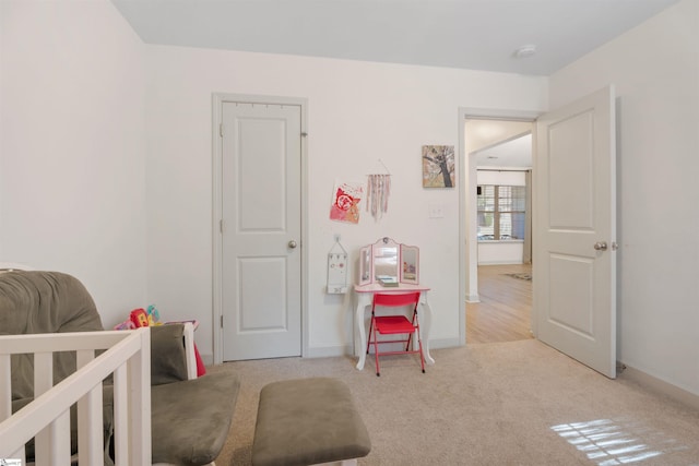 carpeted bedroom featuring a nursery area