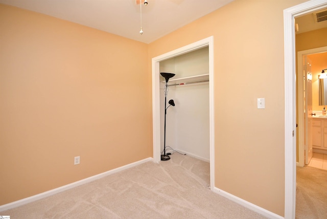 unfurnished bedroom featuring light carpet, a closet, and connected bathroom