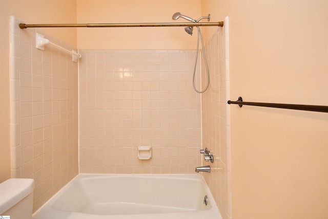 bathroom with toilet and tiled shower / bath