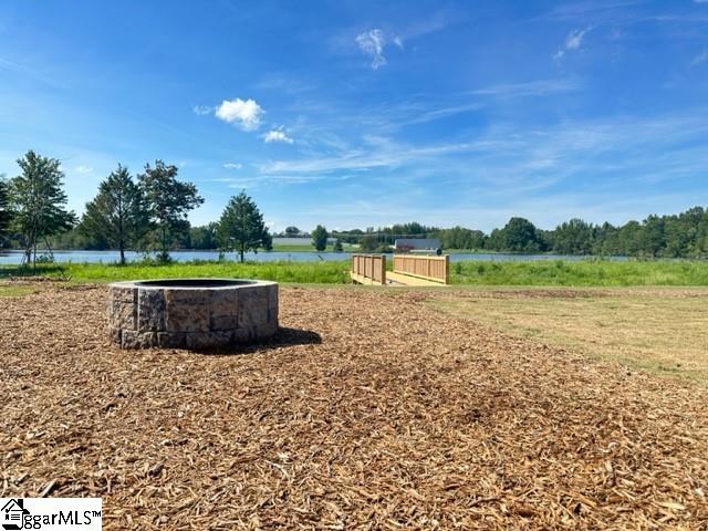 view of property's community featuring a water view and an outdoor fire pit