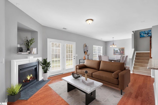 living room with an inviting chandelier and light hardwood / wood-style flooring