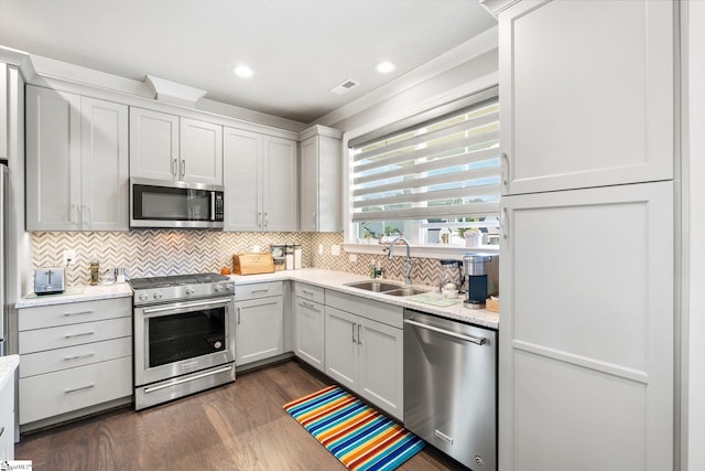 kitchen featuring stainless steel appliances, dark hardwood / wood-style floors, sink, and white cabinetry