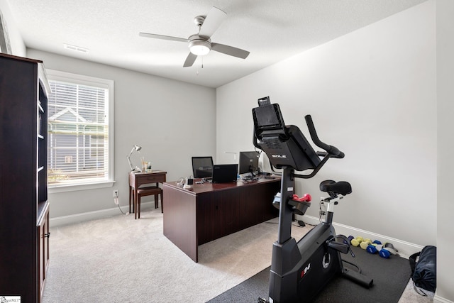 carpeted office space featuring a textured ceiling and ceiling fan