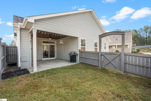 rear view of property with a patio, a lawn, and ceiling fan