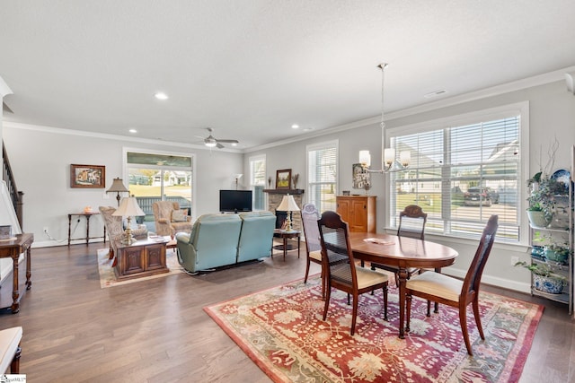 dining room featuring ornamental molding, hardwood / wood-style floors, and ceiling fan with notable chandelier