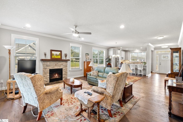 living room with hardwood / wood-style flooring, crown molding, and a textured ceiling