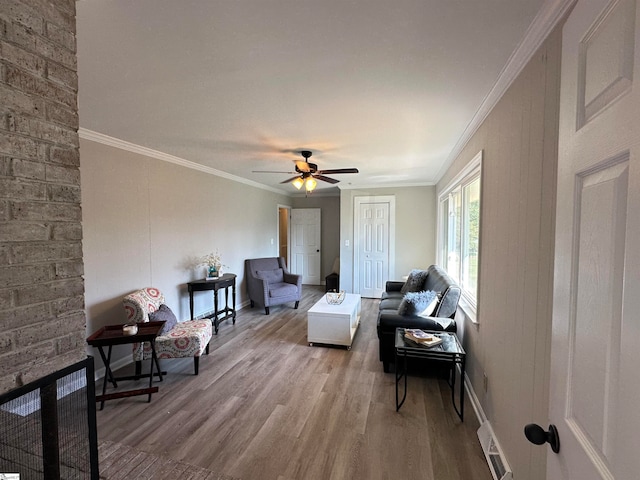 living room with light hardwood / wood-style flooring, ceiling fan, and crown molding