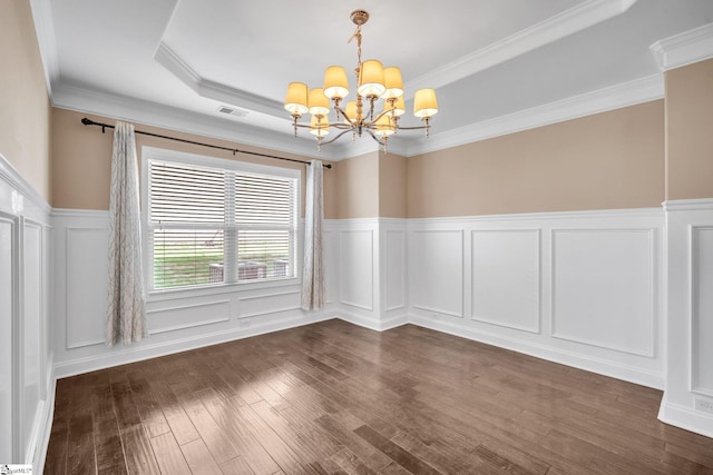 unfurnished room featuring dark wood-type flooring, a raised ceiling, crown molding, and a notable chandelier