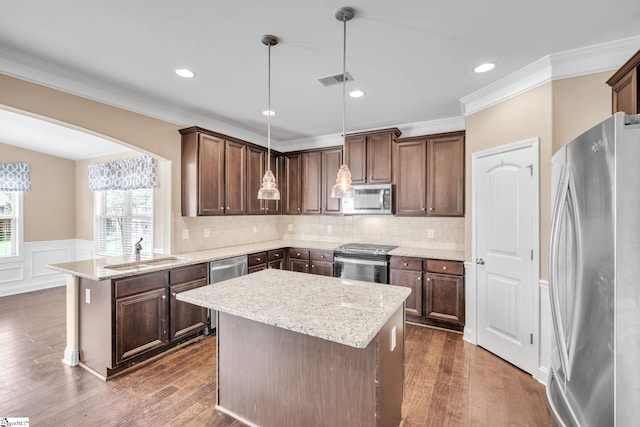 kitchen featuring stainless steel appliances, dark wood-type flooring, and decorative light fixtures