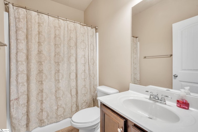 bathroom with walk in shower, vanity, and toilet