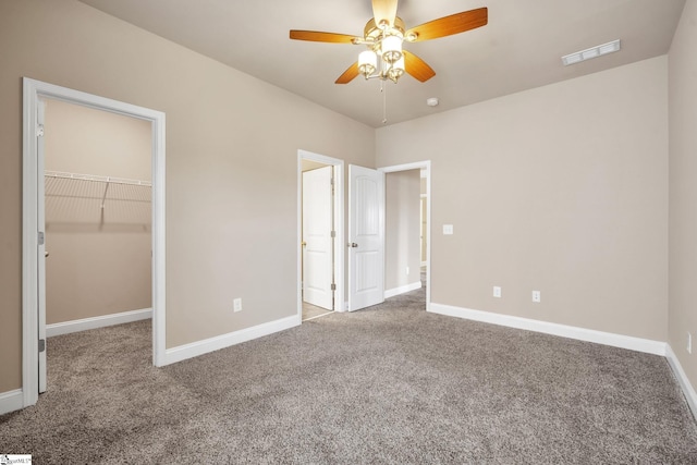 unfurnished bedroom with ceiling fan, carpet floors, a closet, and a spacious closet