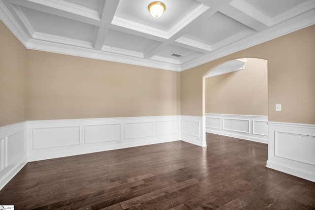 empty room featuring coffered ceiling, ornamental molding, beam ceiling, and dark hardwood / wood-style flooring