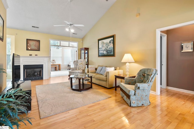 living room featuring ceiling fan, light hardwood / wood-style flooring, and high vaulted ceiling