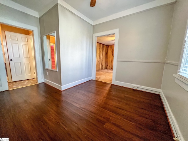 empty room with ceiling fan and dark hardwood / wood-style flooring