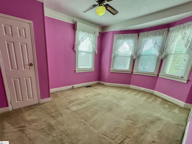 empty room with ceiling fan and carpet