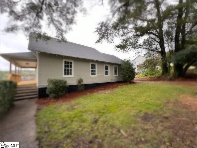 view of side of home with a yard