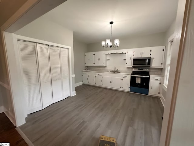 kitchen featuring white cabinetry, decorative light fixtures, sink, and black stove