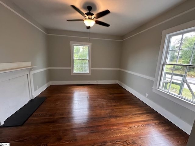 unfurnished room featuring ceiling fan, plenty of natural light, and dark wood-type flooring