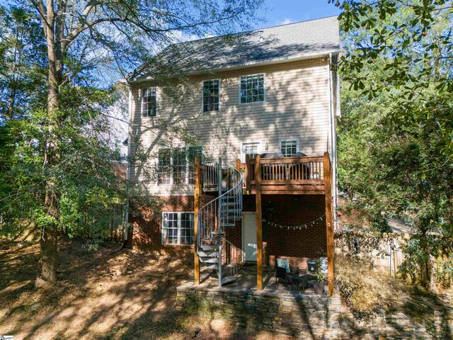 rear view of property featuring a wooden deck