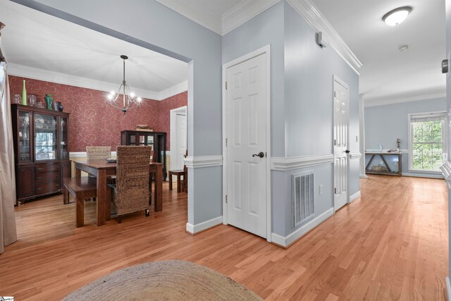 hallway featuring ornamental molding and light hardwood / wood-style flooring