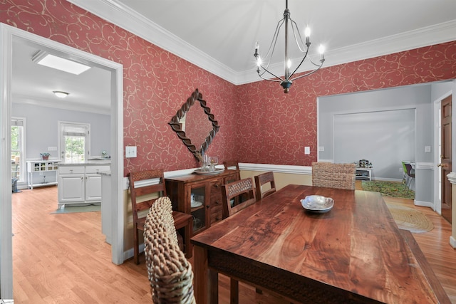 dining room featuring a notable chandelier, ornamental molding, and light hardwood / wood-style flooring