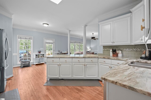 kitchen with light hardwood / wood-style floors, white cabinets, and ceiling fan