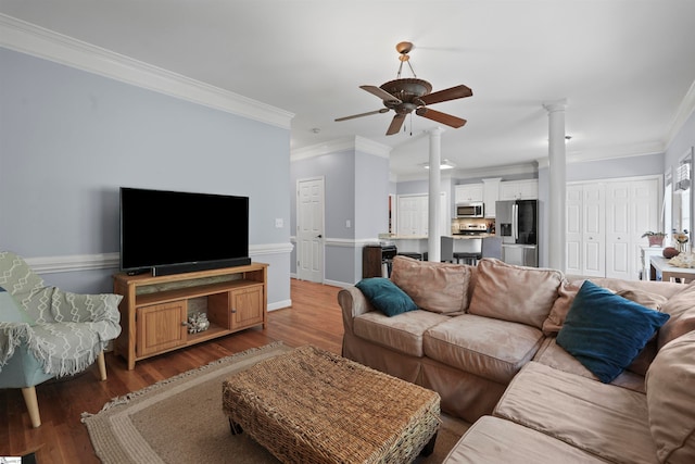 living room featuring wood-type flooring, ornamental molding, and ceiling fan