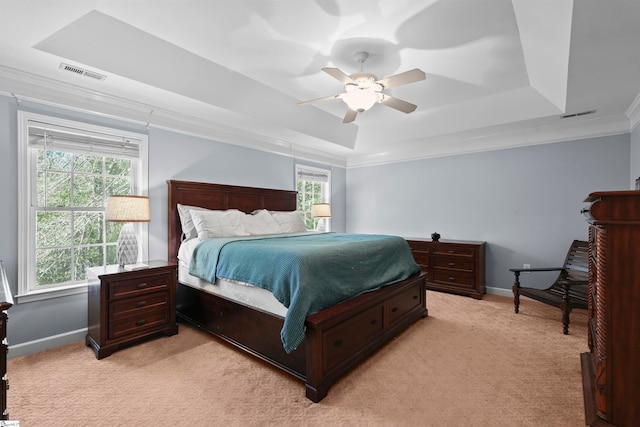 carpeted bedroom with ornamental molding, multiple windows, ceiling fan, and a raised ceiling