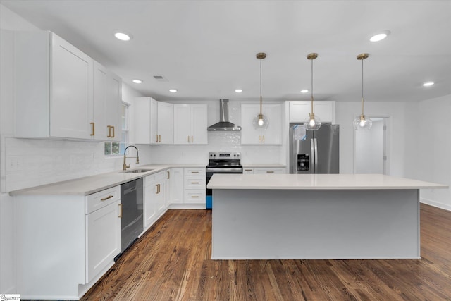 kitchen featuring stainless steel appliances, wall chimney range hood, white cabinets, and a center island