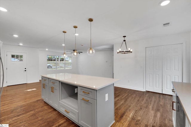 kitchen featuring pendant lighting, gray cabinets, a kitchen island, and dark hardwood / wood-style floors