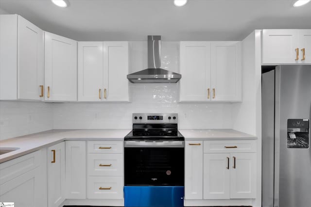 kitchen featuring wall chimney range hood, white cabinetry, stainless steel appliances, and backsplash