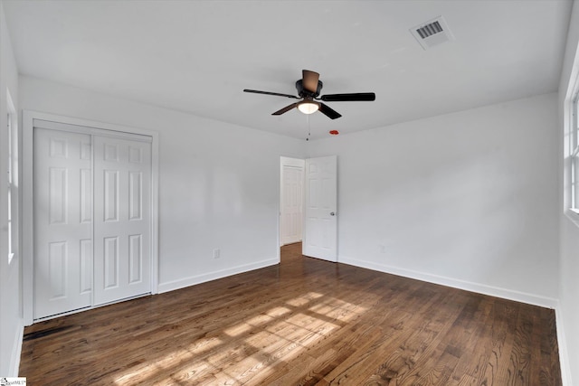 unfurnished bedroom featuring ceiling fan, a closet, and dark hardwood / wood-style flooring