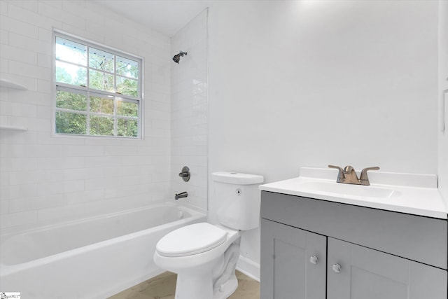 full bathroom featuring vanity, tiled shower / bath combo, and toilet