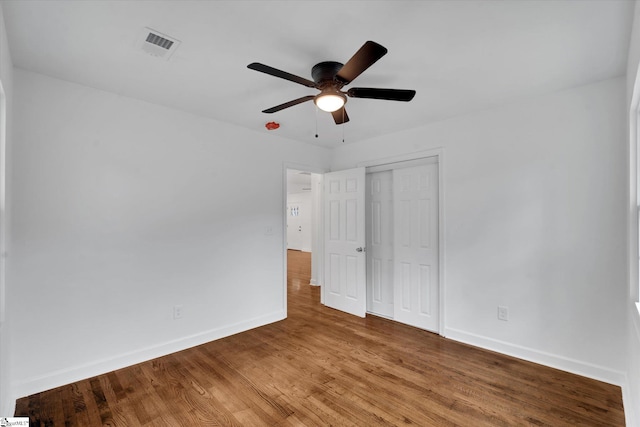 unfurnished bedroom with a closet, hardwood / wood-style flooring, and ceiling fan