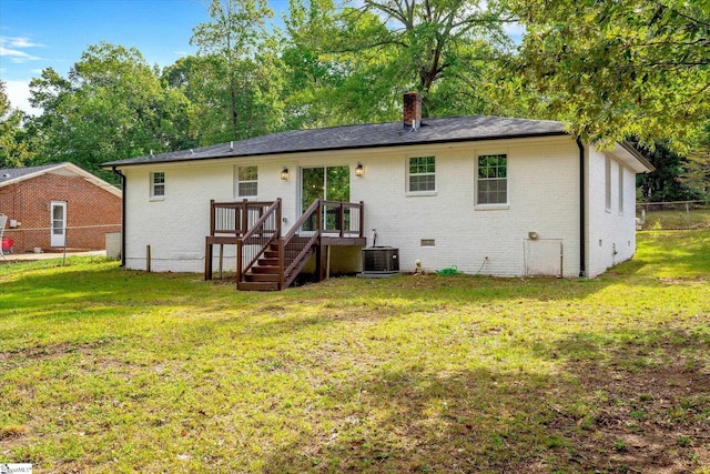 rear view of property with a lawn and central AC unit