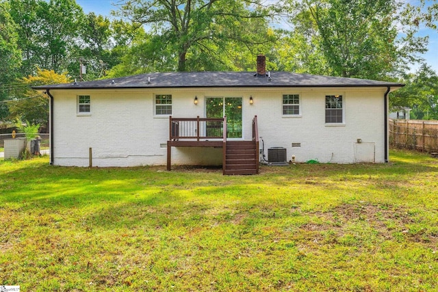 back of property with a wooden deck and a lawn