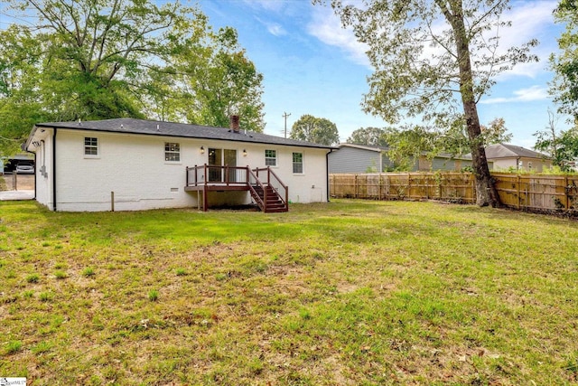 rear view of house with a deck and a lawn