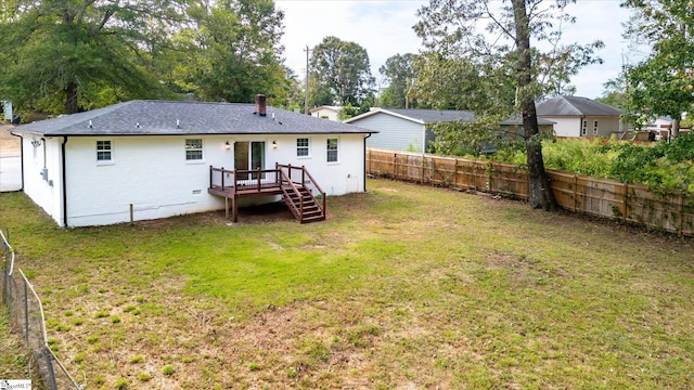 back of property featuring a yard and a deck