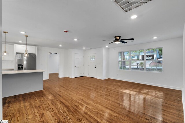 unfurnished living room with ceiling fan and hardwood / wood-style floors