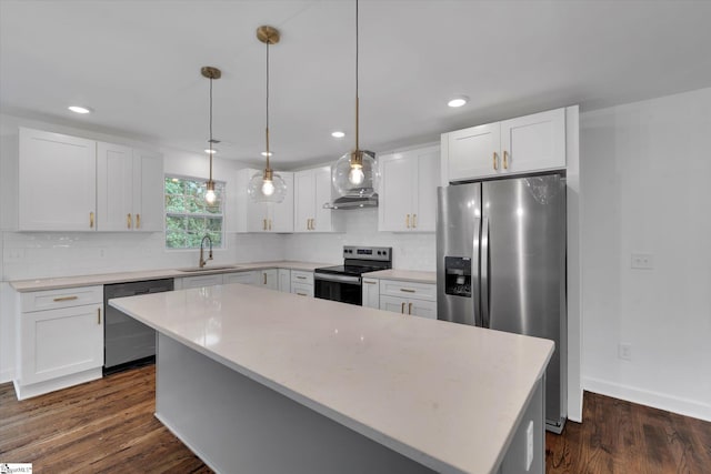 kitchen featuring appliances with stainless steel finishes, pendant lighting, a center island, and white cabinets