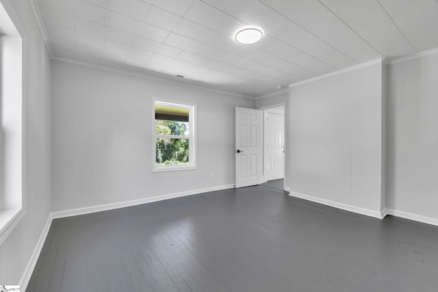 empty room featuring dark hardwood / wood-style floors and crown molding