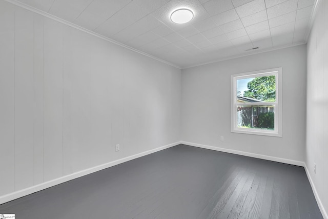 empty room featuring dark hardwood / wood-style flooring and crown molding